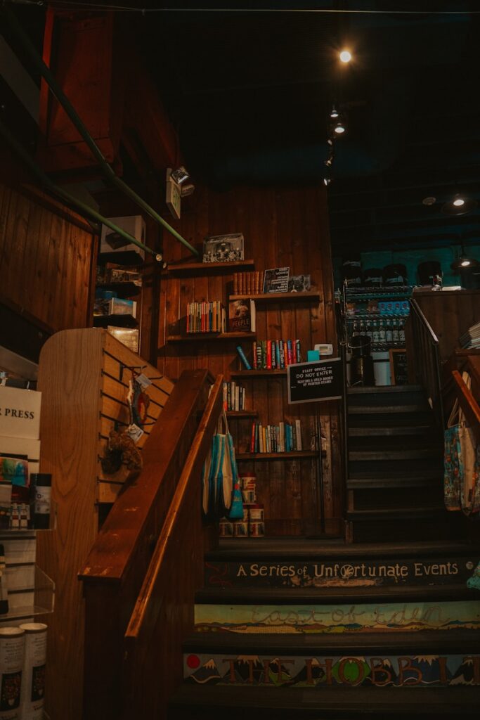 Cozy bookstore interior with a wooden staircase.